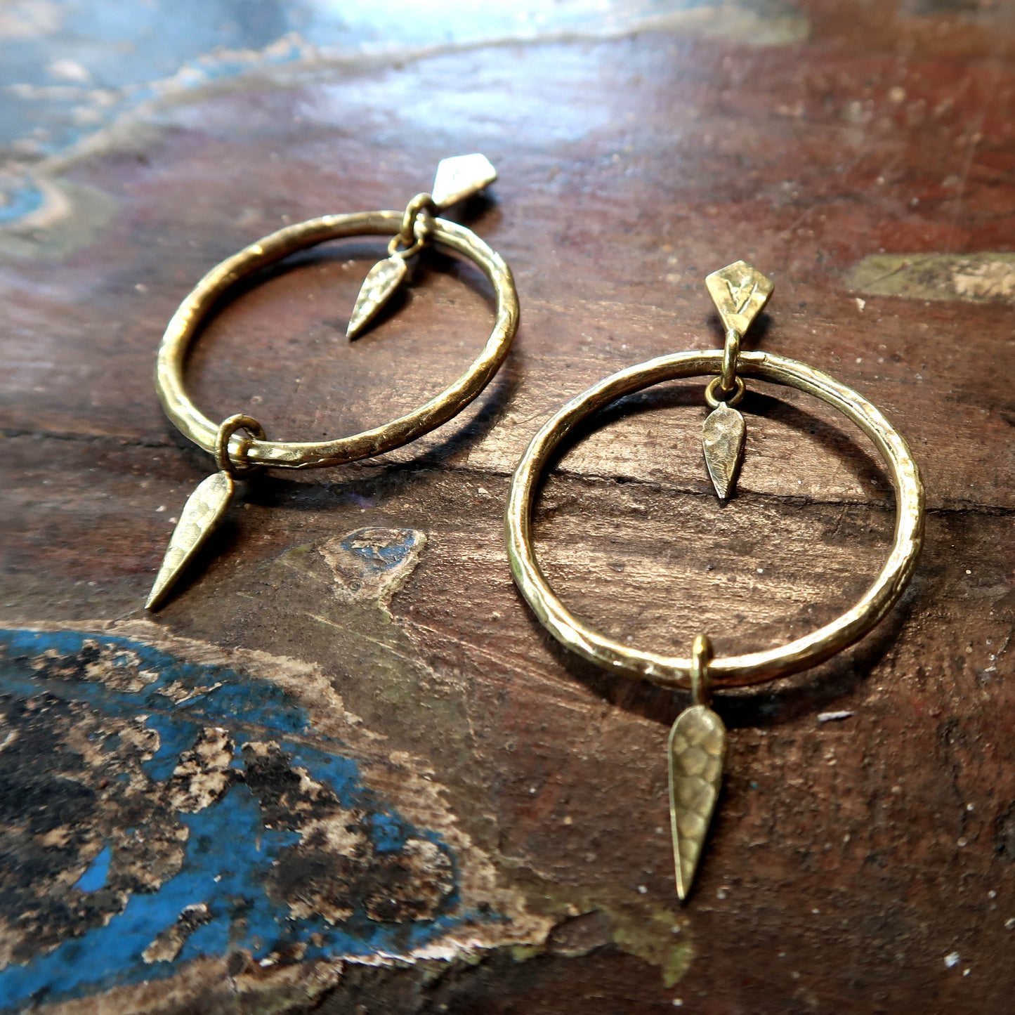 Handcrafted artisan earrings in Italian brass, featuring textured hoops and dynamic pendants. Ethically made, hypoallergenic, and perfect for timeless, sophisticated style.